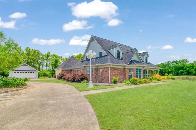 a front view of a house with a garden and trees