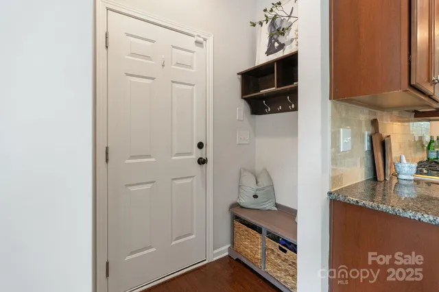 a kitchen with stainless steel appliances kitchen island granite countertop a refrigerator a stove a sink a dining table and chairs with wooden floor