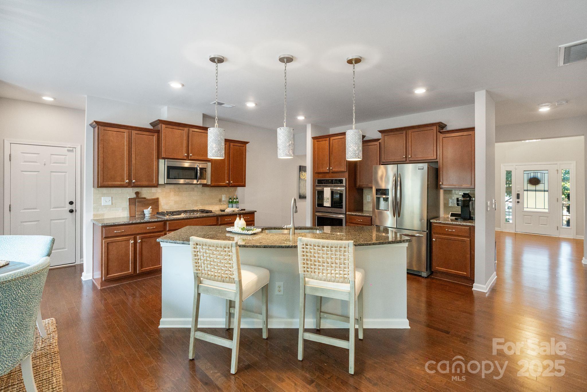 2005 Brightflower Lane York, SC 29745 - Photo 19 of 48 a kitchen with stainless steel appliances granite countertop a refrigerator a stove top oven a sink dishwasher and white cabinets with wooden floor