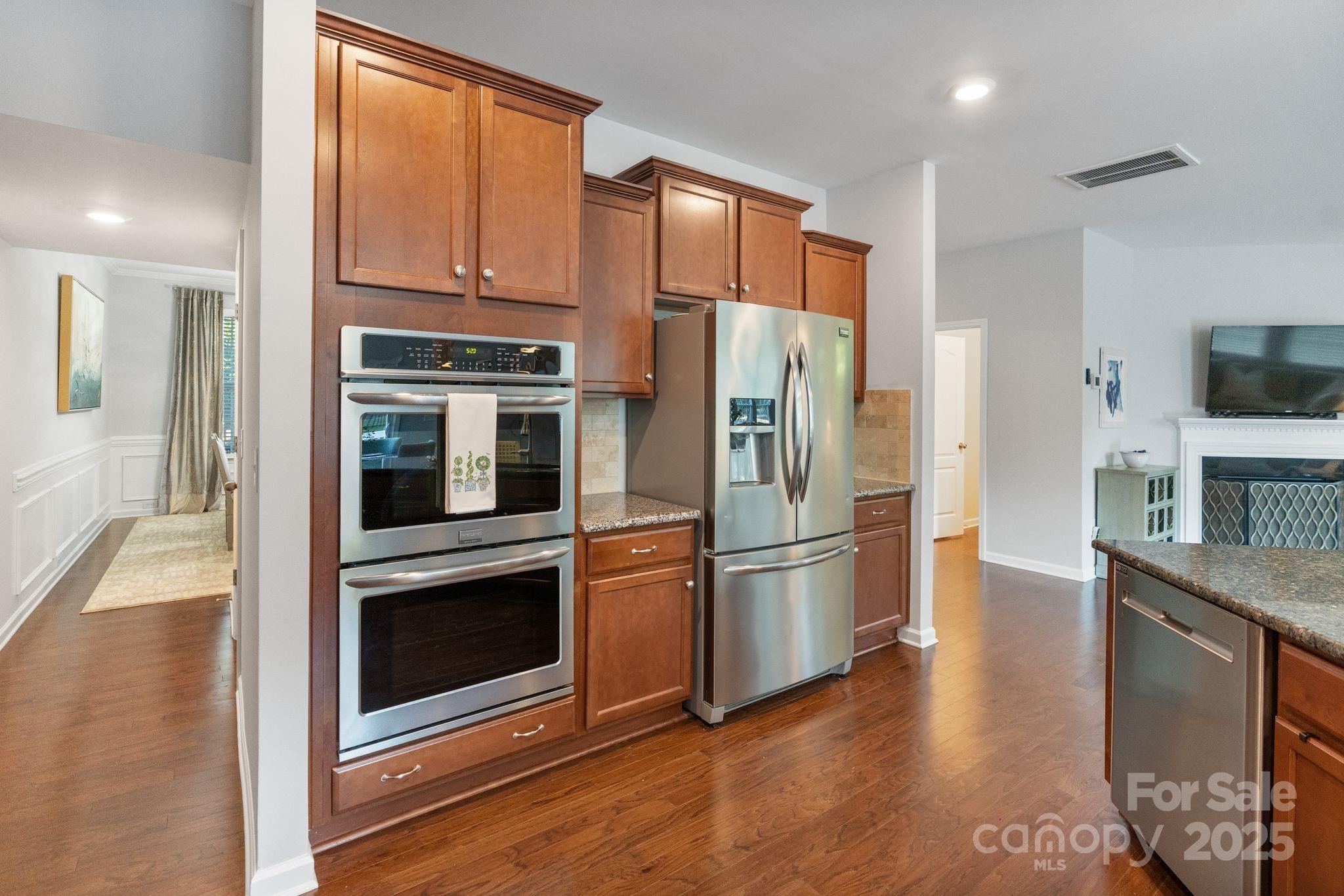 2005 Brightflower Lane York, SC 29745 - Photo 22 of 48 a kitchen with stainless steel appliances granite countertop a refrigerator microwave and wooden floor