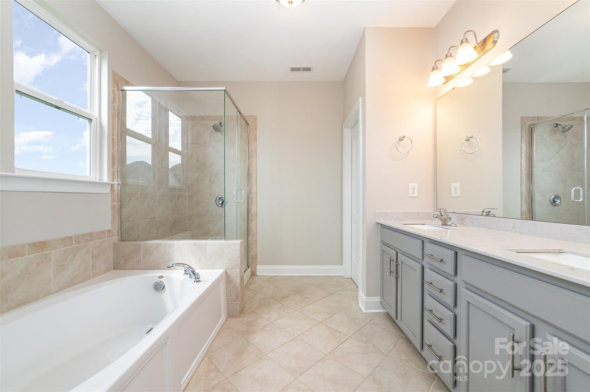 10024 Fox Trotter Lane Midland, NC 28107 - Photo 24 of 43 a bathroom with a granite countertop bathtub a sink and a large mirror