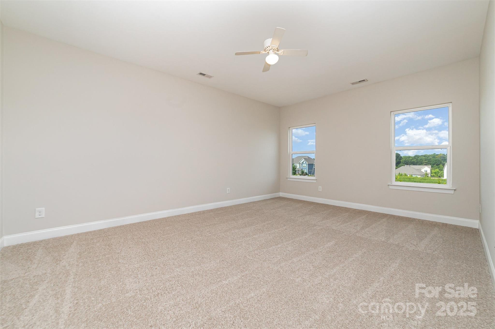 10024 Fox Trotter Lane Midland, NC 28107 - Photo 29 of 43 an empty room with windows and chandelier fan