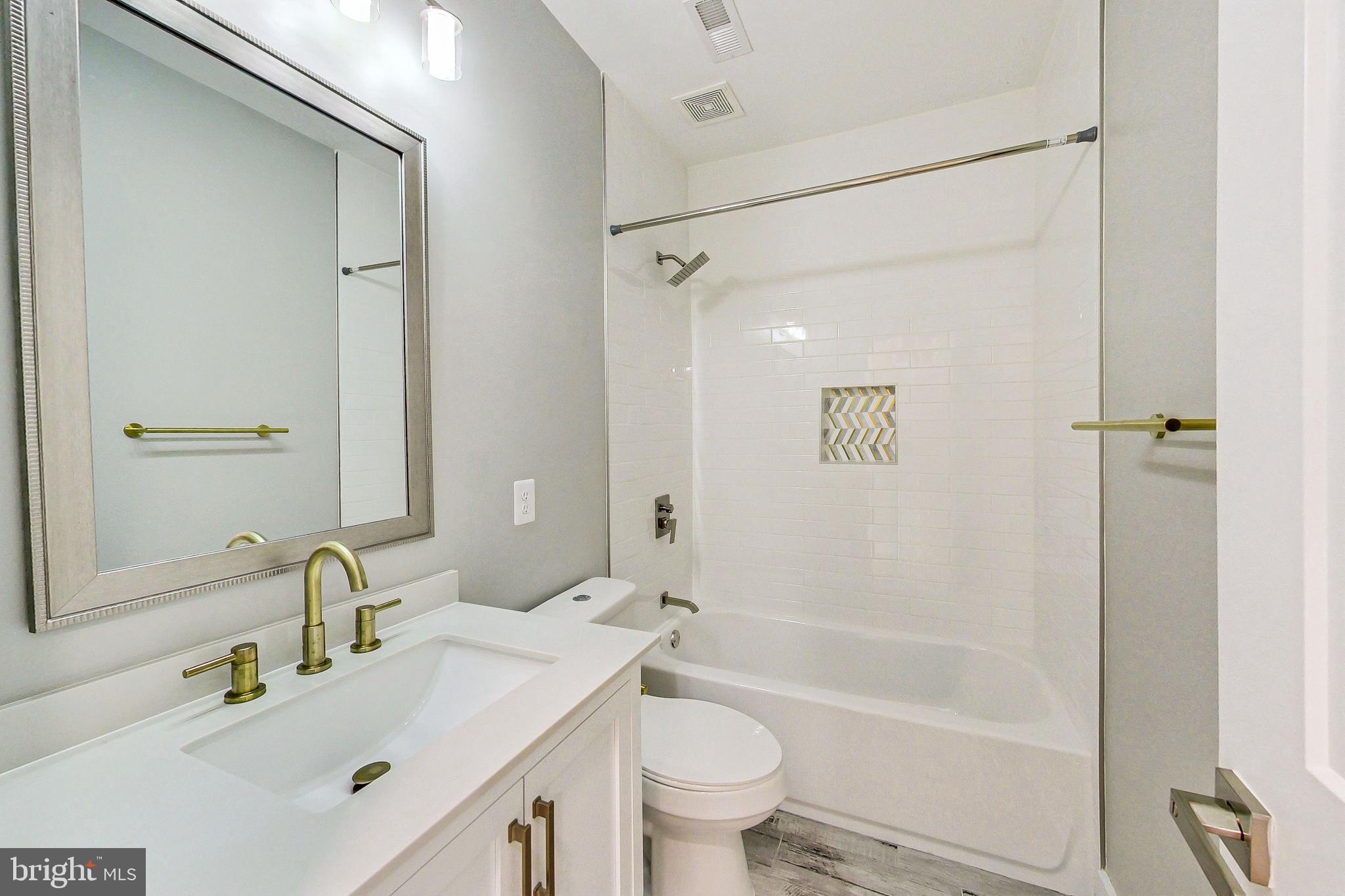 1124 Owen Place Northeast Washington, DC 20002 - Photo 12 of 19 a bathroom with a bathtub shower sink vanity mirror and toilet