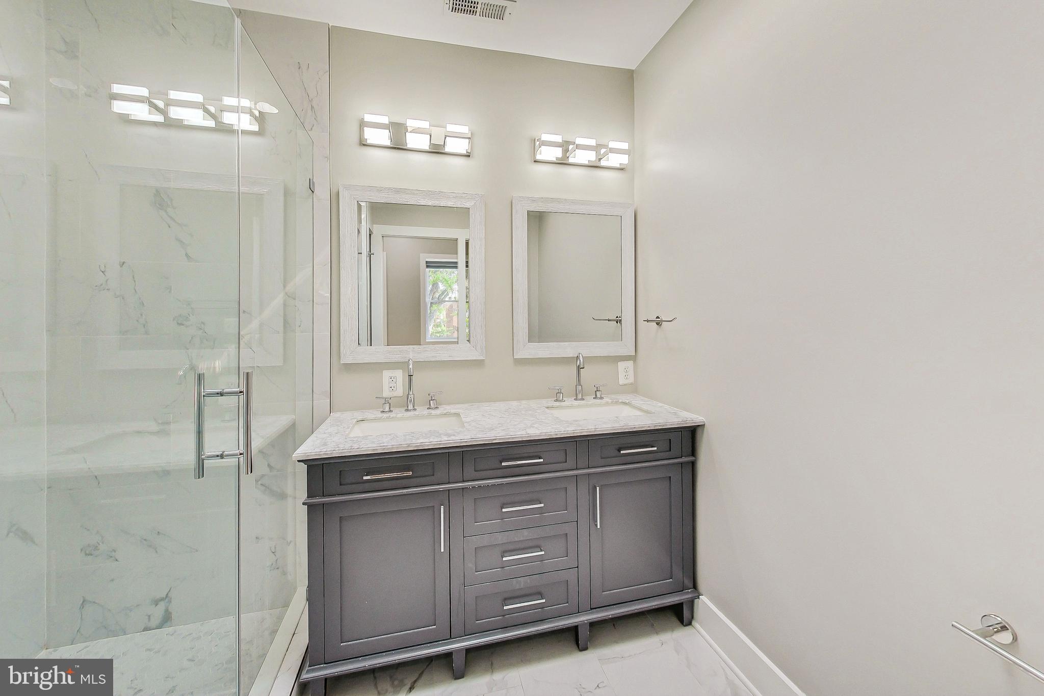 1124 Owen Place Northeast Washington, DC 20002 - Photo 9 of 19 a bathroom with a granite countertop sink a mirror and a shower