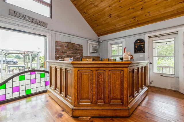 a utility room with stainless steel appliances wooden floor and a large window