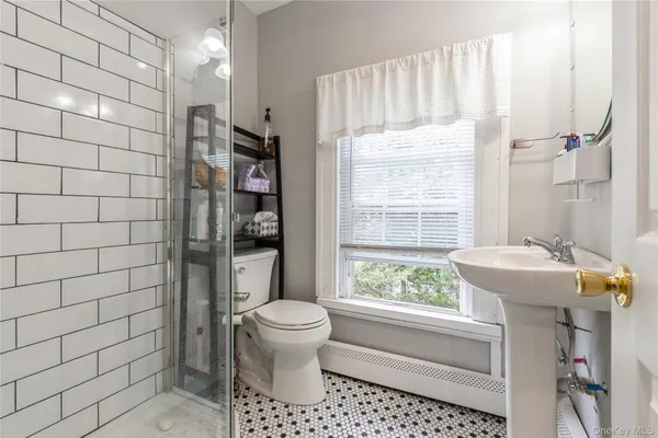a bathroom with a sink a toilet and shower
