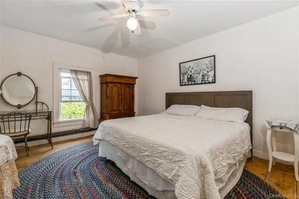 a bedroom with a large bed and wooden floor