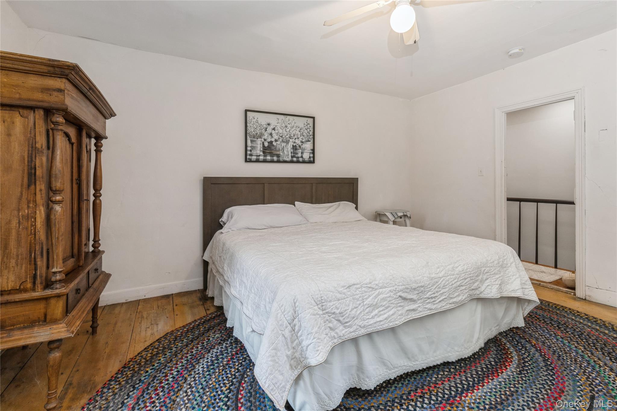 35950 Main Road Cutchogue, NY 11935 - Photo 27 of 39 a bedroom with a bed and a chandelier