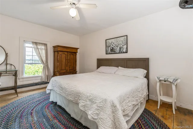 a bedroom with a bed wooden floor and window