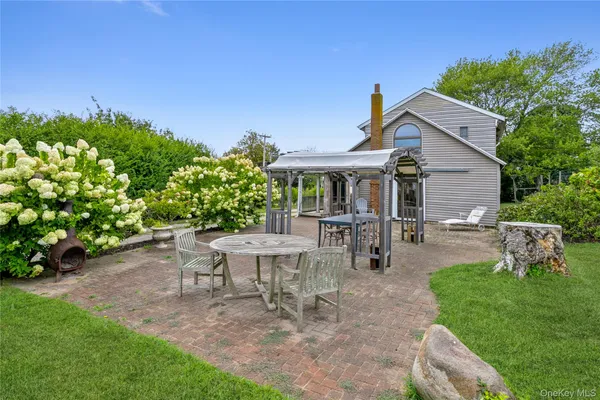 a view of a house with backyard sitting area and garden