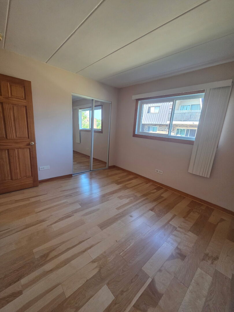 10510 Parkside Avenue, Unit 7 Chicago Ridge, IL 60415 - Photo 3 of 11 an empty room with wooden floor and windows