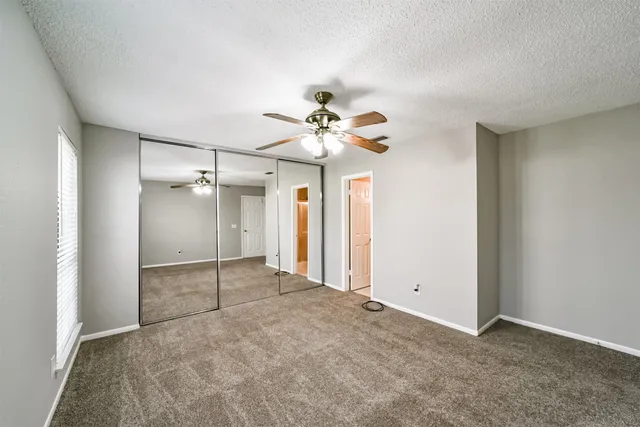 an empty room with fan and entrance