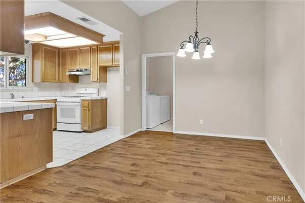 a view of a kitchen with a sink and chandelier