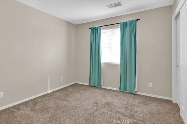 an empty room with closet and a window