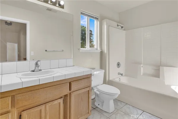 a bathroom with a granite countertop sink toilet a mirror and shower