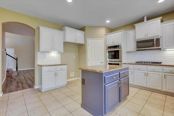 a bathroom with a granite countertop sink toilet and mirror