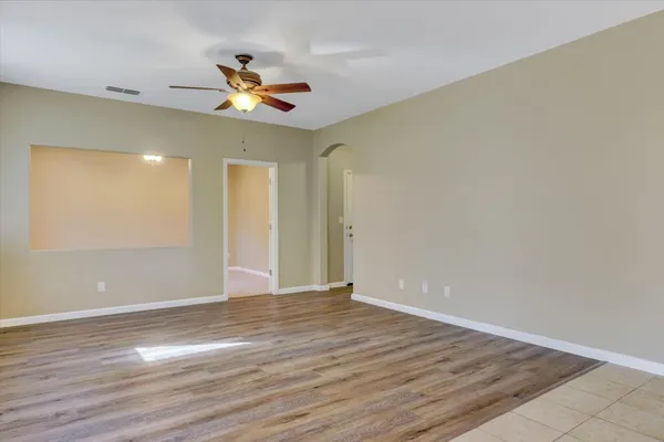 a view of an empty room with closet and a bathroom