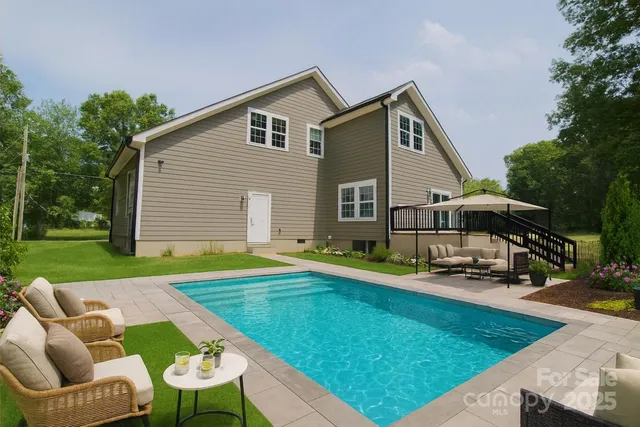 a view of a house with backyard and trees