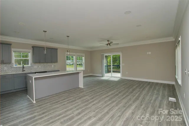 a view of a kitchen with a sink a ceiling fan and refrigerator