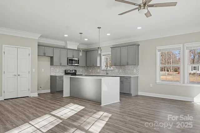 a kitchen with a refrigerator a sink and a stove top oven