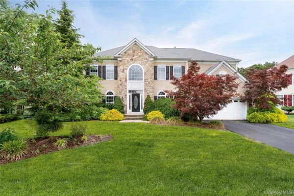 a front view of a house with a garden and yard