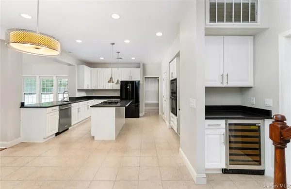 a kitchen with stainless steel appliances kitchen island granite countertop a stove a sink and a refrigerator