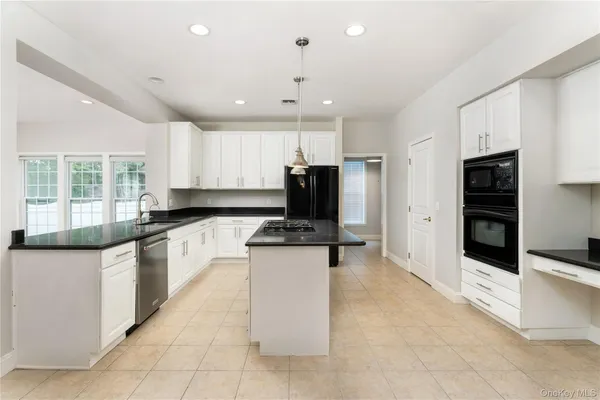 a kitchen with stainless steel appliances granite countertop a refrigerator and a stove