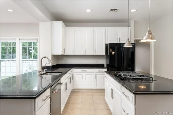 a kitchen with granite countertop a sink stainless steel appliances and cabinets
