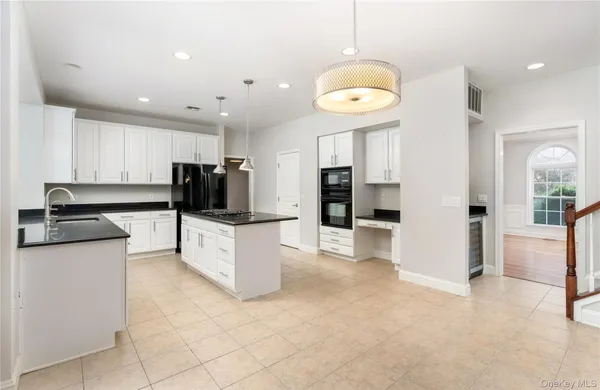 a large white kitchen with lots of counter space and stainless steel appliances