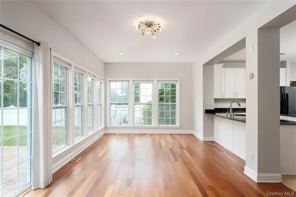 a view of a kitchen with wooden floor and a window