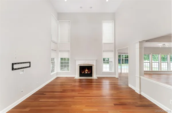 a view of a livingroom with wooden floor and a fireplace
