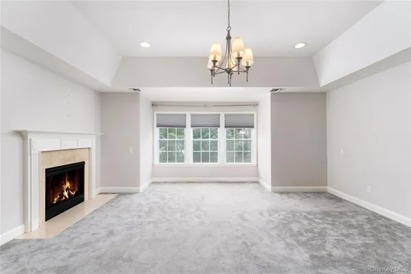 a view of an empty room with window and fire place