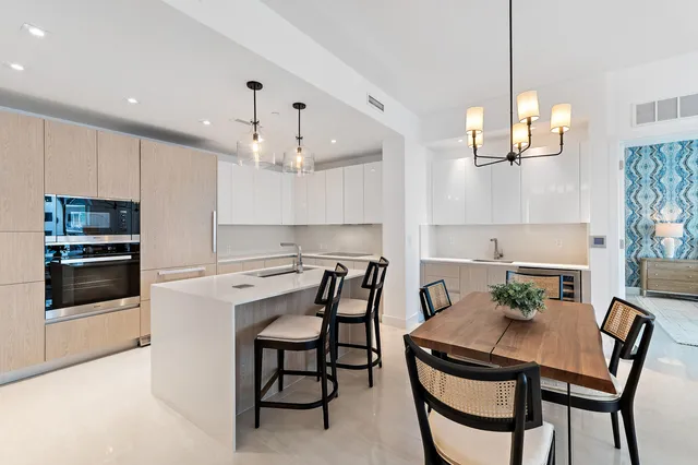 a open kitchen with stainless steel appliances kitchen island granite countertop a sink and white cabinets