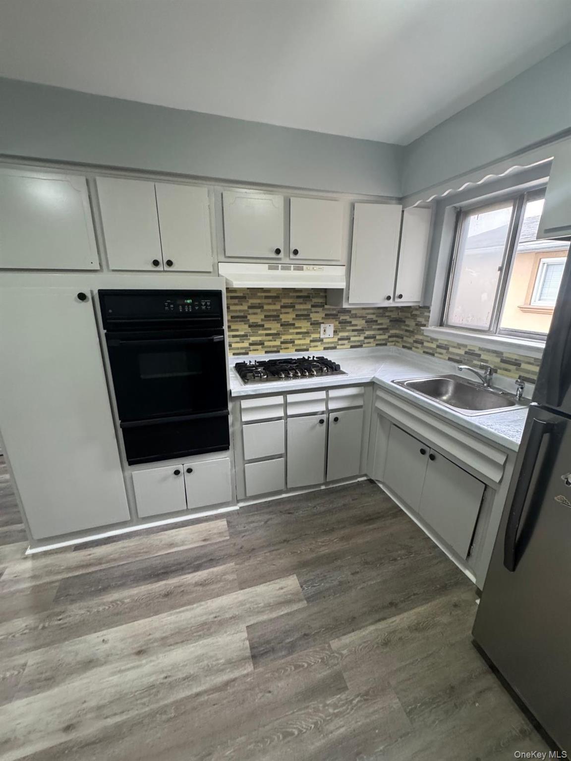 116-23 Inwood Street Queens, NY 11436 - Photo 11 of 22 a kitchen with stainless steel appliances granite countertop a stove a sink and a microwave