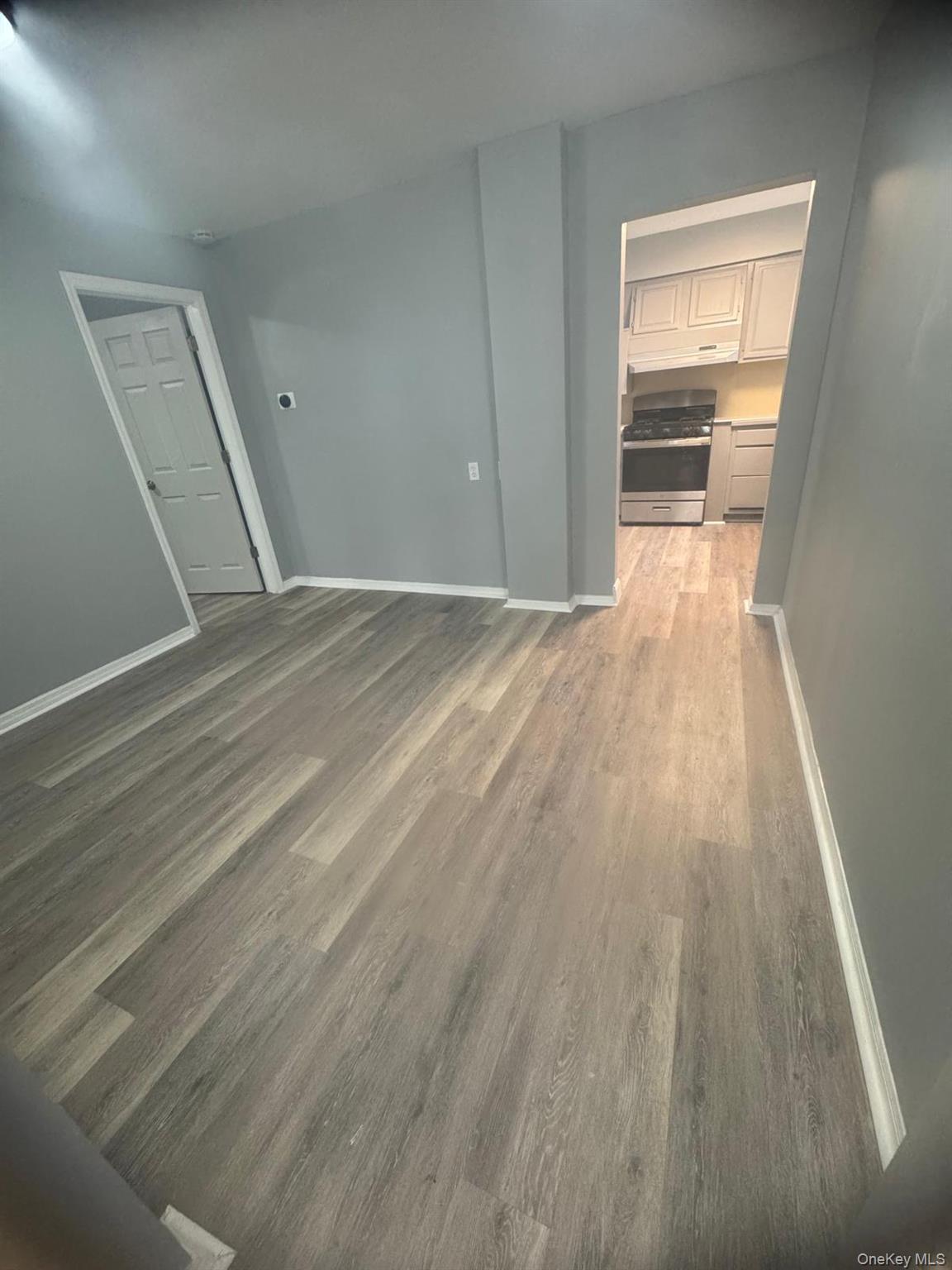 116-23 Inwood Street Queens, NY 11436 - Photo 20 of 22 an empty room with wooden floor and a window