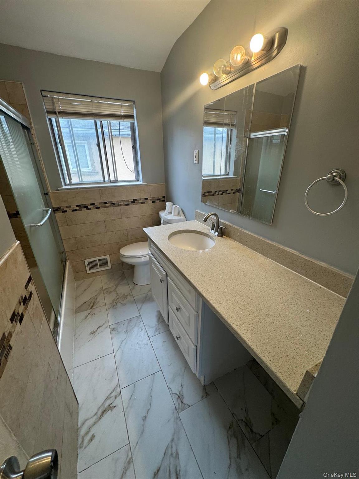 116-23 Inwood Street Queens, NY 11436 - Photo 7 of 22 a spacious bathroom with a double vanity sink a mirror and a bathtub