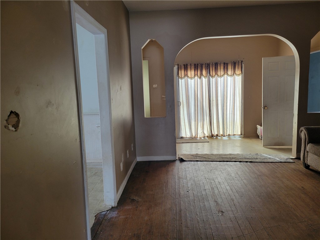 1208 East Main Street Seneca, SC 29678 - Photo 11 of 19 This living area features a classic arched doorway and rich wood flooring.