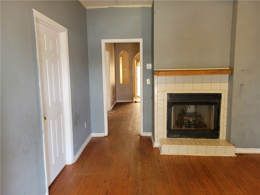 1208 East Main Street Seneca, SC 29678 - Photo 8 of 19 This inviting space features classic hardwood floors and a cozy fireplace, perfect for relaxation.