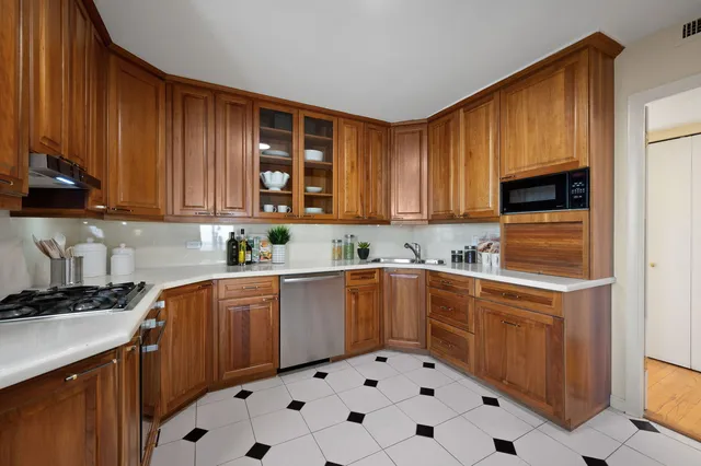 a kitchen with stainless steel appliances a stove a sink and a microwave