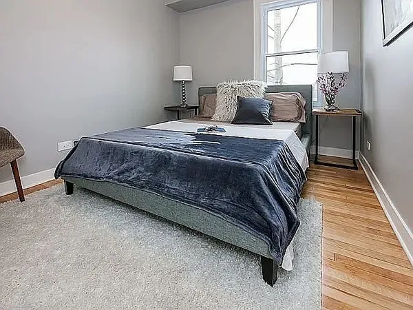 a bedroom with a bed and wooden floor