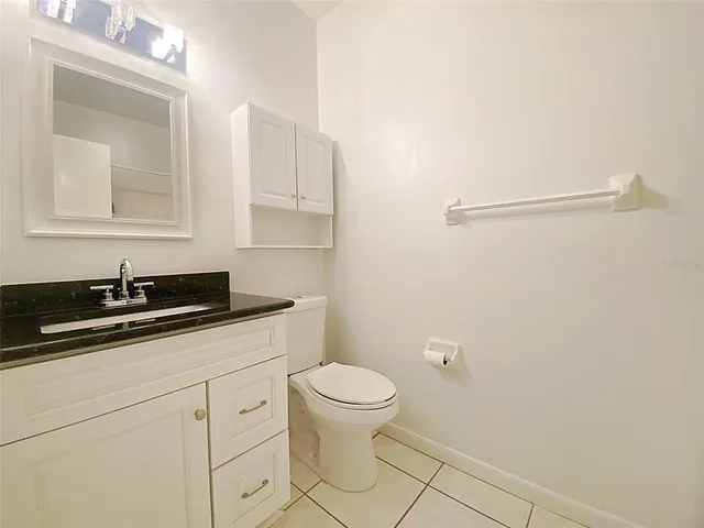 a bathroom with a sink a toilet a light fixture and mirror