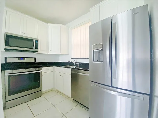 a kitchen with stainless steel appliances granite countertop a refrigerator sink and microwave