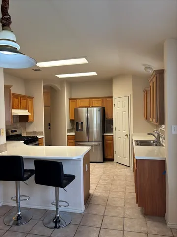 a large living room with stainless steel appliances kitchen island granite countertop a table and chairs