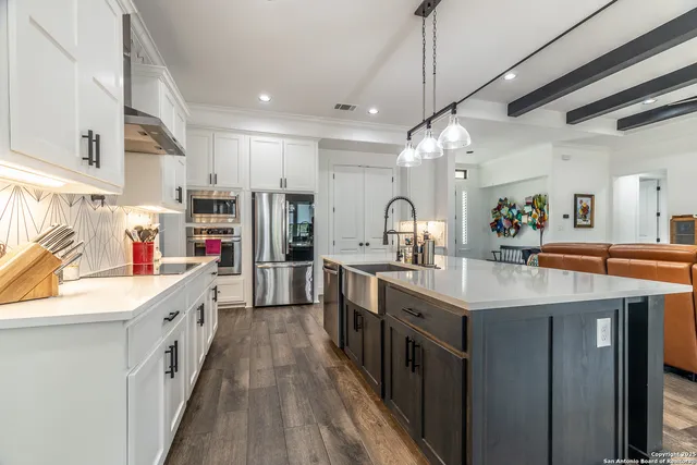 a kitchen with kitchen island a sink a counter top space stainless steel appliances and a window