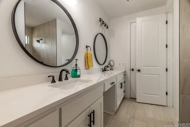 a bathroom with a double vanity sink and a mirror