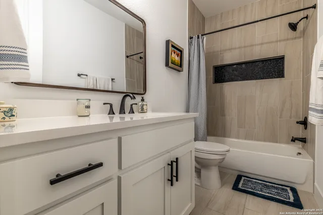 a bathroom with a sink a toilet a shower and a mirror