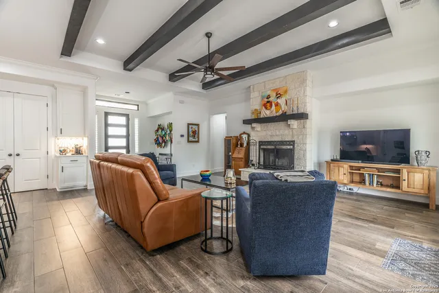 a living room with furniture a flat screen tv and a fireplace