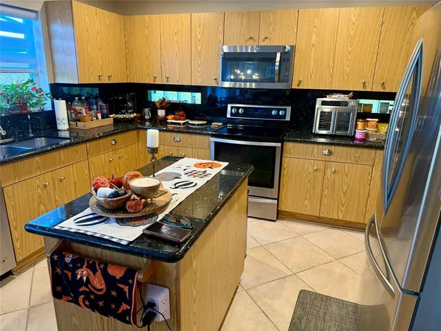 a kitchen with stainless steel appliances granite countertop a stove a sink and a microwave