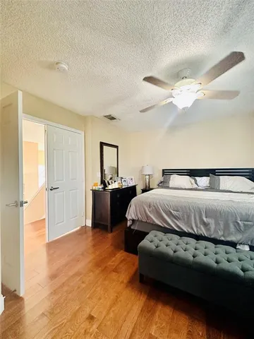 a spacious bedroom with a bed and a chandelier