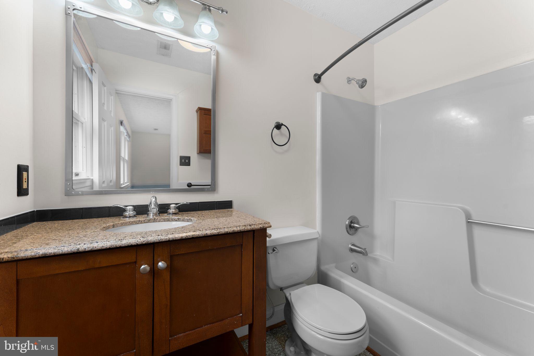 13360 Cameron Court Boston, VA 22713 - Photo 69 of 76 a bathroom with a granite countertop toilet sink and mirror